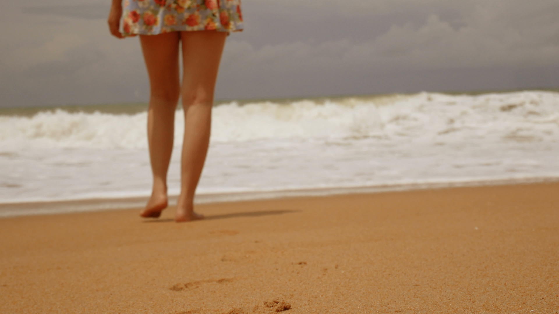 赤脚走在湿沙岛海滩上的年轻女孩在夏天有大浪视频的预览图
