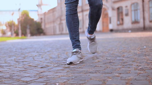 男人的腿在人行道上行走视频的预览图