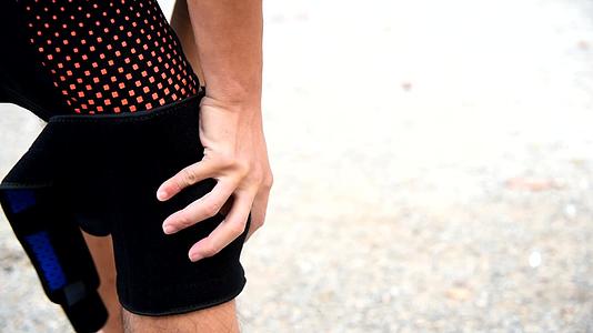 男人用膝盖支撑着膝盖阳光照在公园的膝盖上视频的预览图