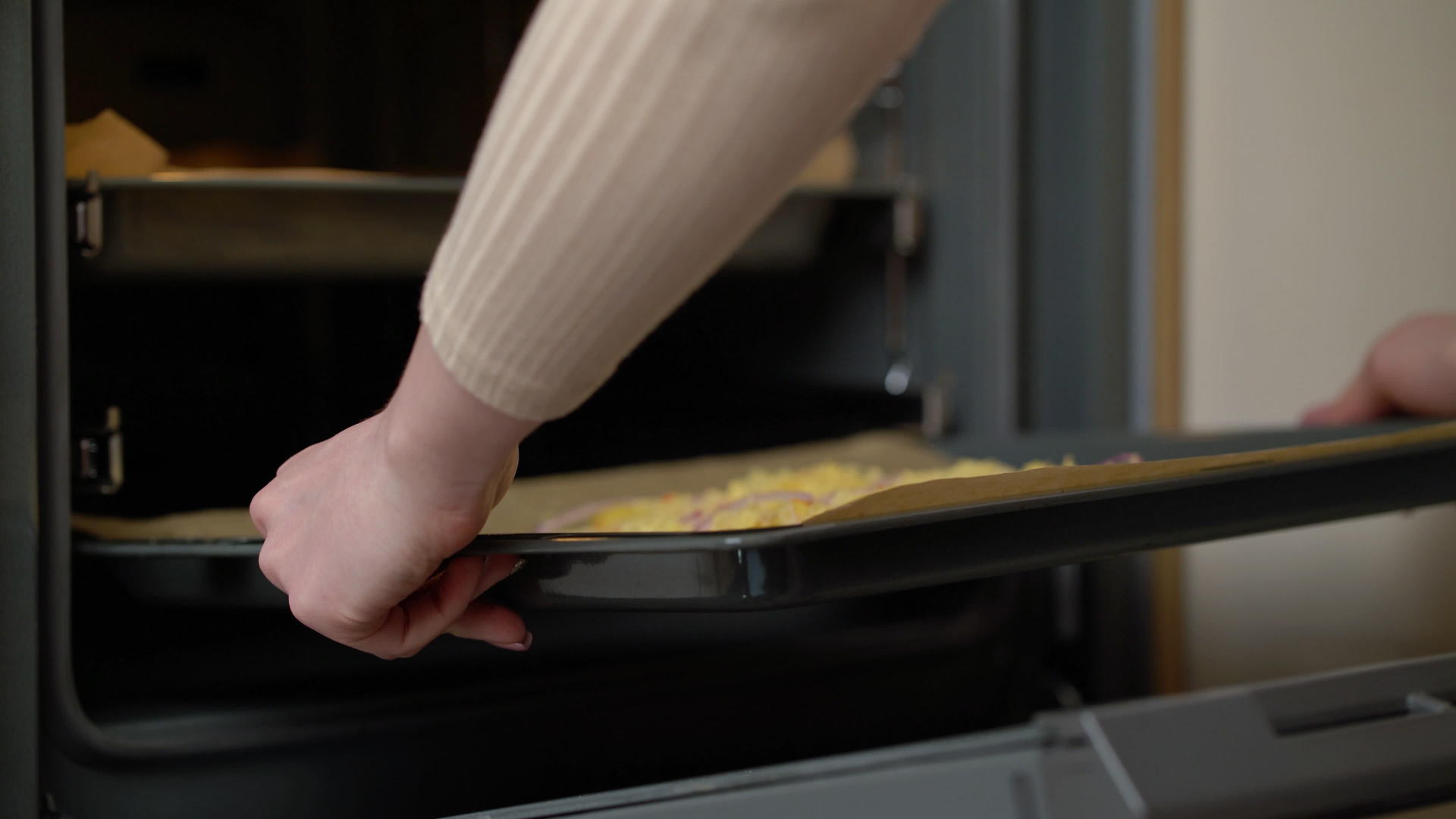 女人把自制披萨放在热烤箱里准备自制披萨视频的预览图