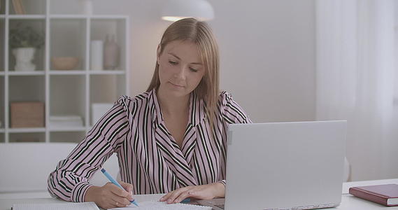 女性自学和电子学习正在关注展示笔记本电脑和纸张视频的预览图