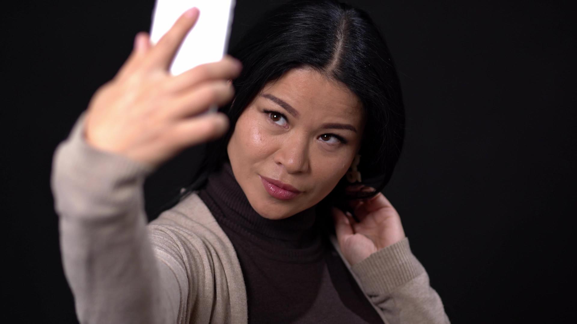 美丽的亚洲人在黑色背景上自拍视频的预览图