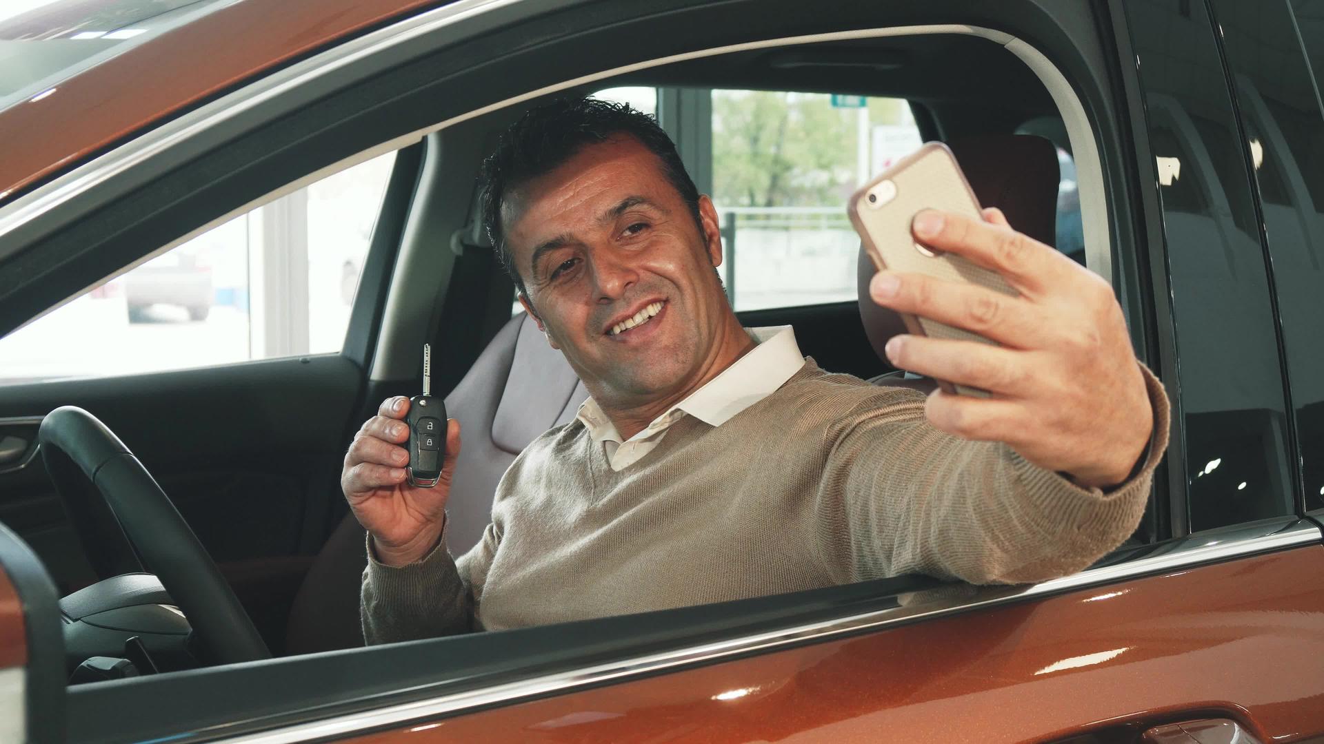 一个坐在车里的快乐男人用钥匙自拍视频的预览图