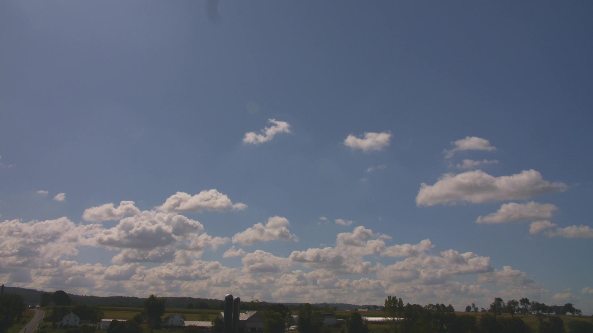白蓝天上有白色的烟云与农场和农村一起向左缓慢向右缓慢视频的预览图