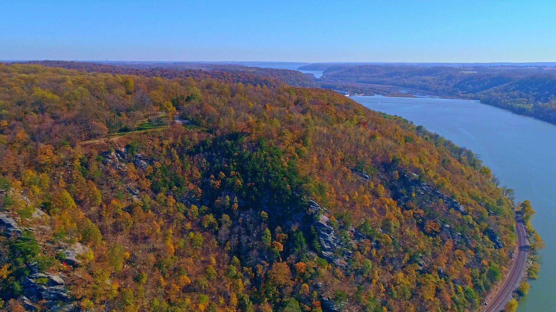 在阳光明媚的秋天你可以看到秋天树木的颜色沿着一条主要河流的天空视频的预览图