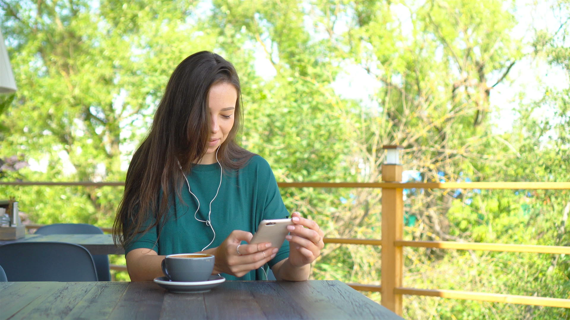 女人在咖啡馆喝咖啡微笑着在手机上发短信智能手机视频的预览图