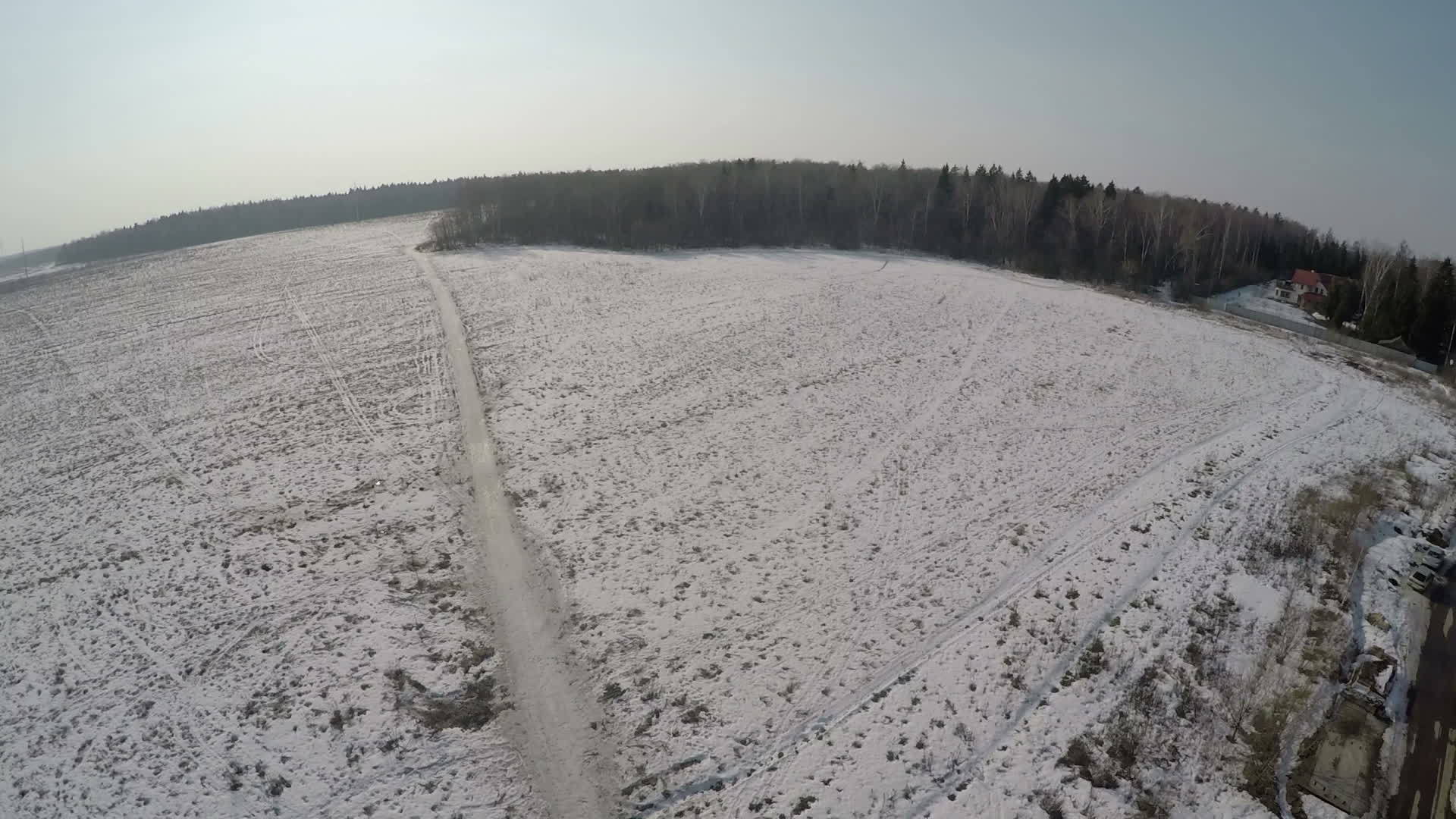 在森林附近的大片雪地村庄的空中观察视频的预览图