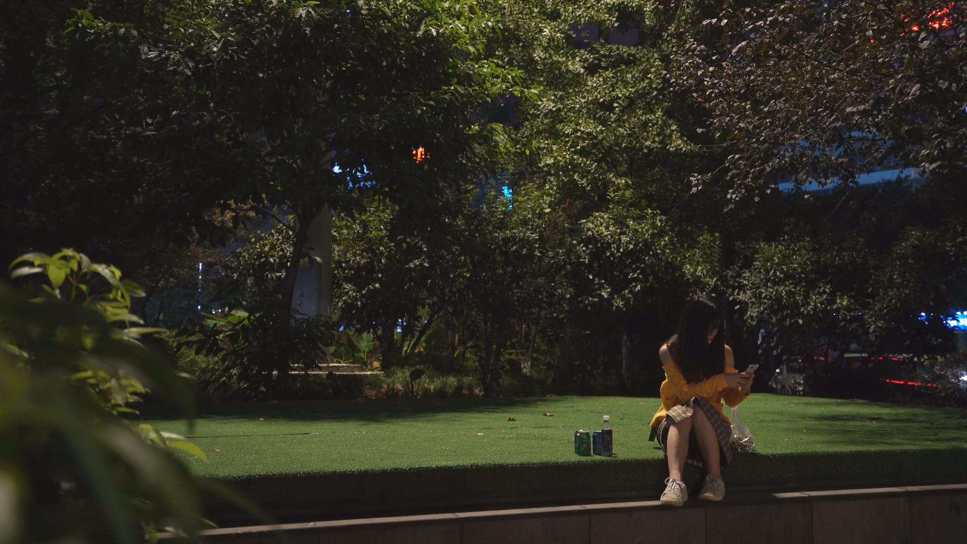 晚上独自一人独坐路边耍手机的小姐姐视频的预览图