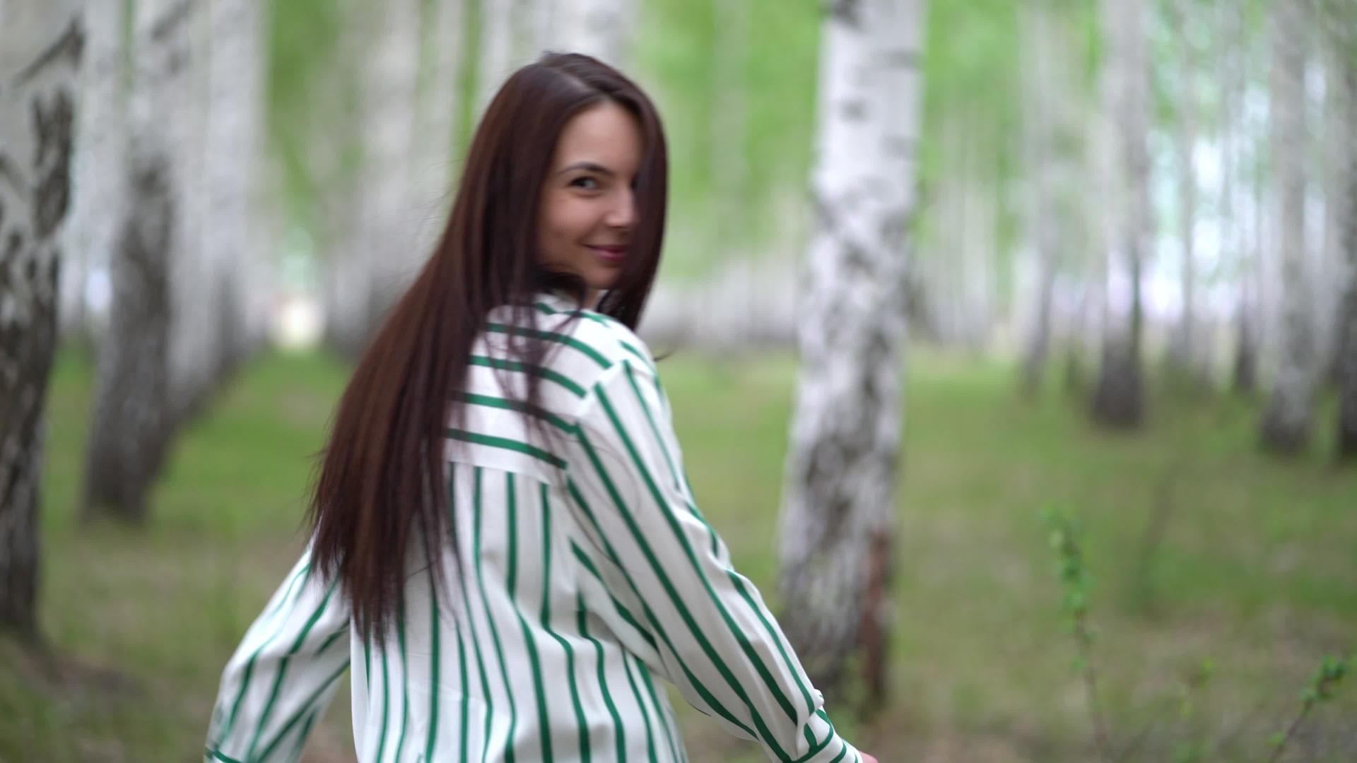春天女孩穿过树林里的白树小巷视频的预览图