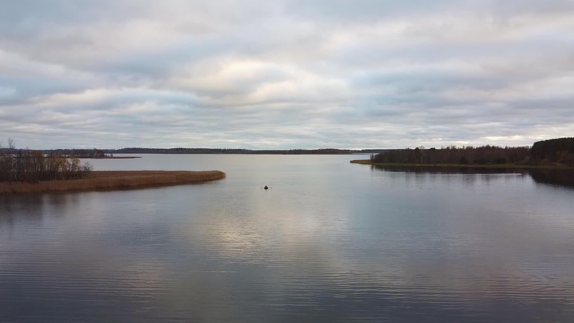 一艘载有渔民的渔船在秋天清晨在空中捕鱼视频的预览图