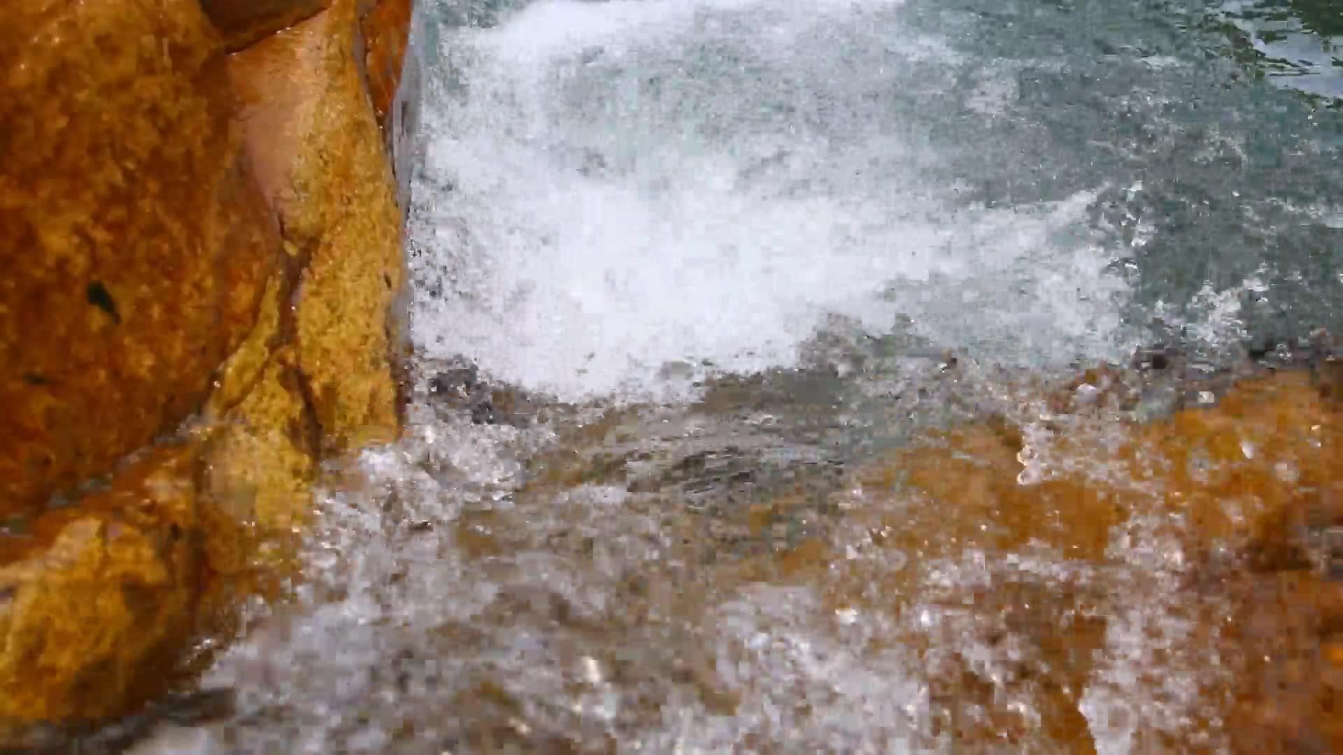 清澈的泉水在岩石的溪流中流淌视频的预览图