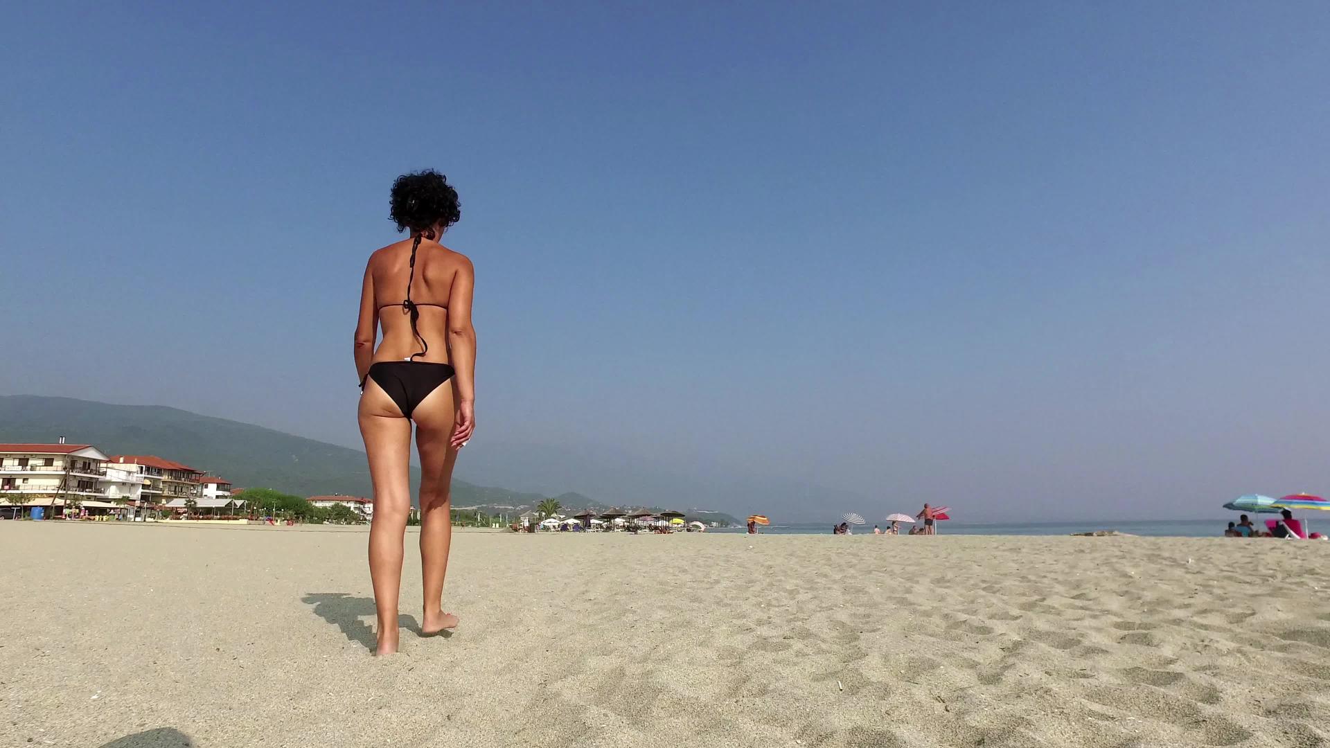 性感的女人走在空海滩上视频的预览图