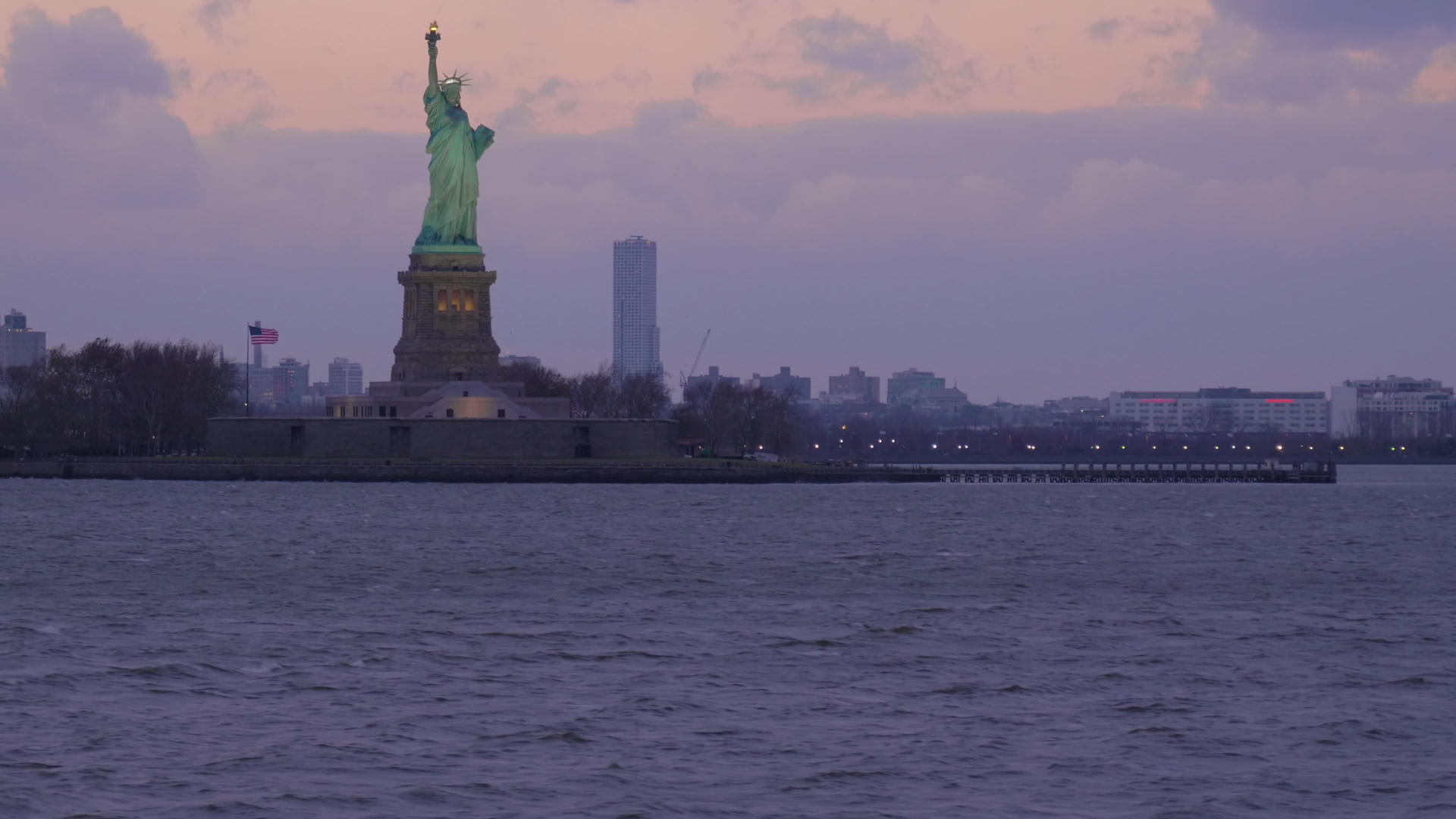 多云的夜晚灯火通明的自由女神像美国纽约市视频的预览图