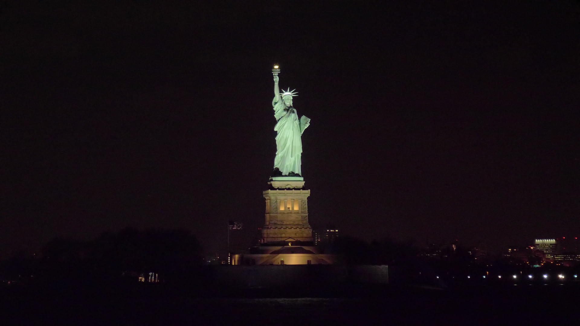 晚上在纽约的自由雕像上...观察水中的轨道视频的预览图