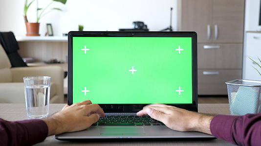 男人在笔记本电脑上打字时用绿屏染色体模拟视频的预览图