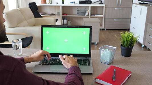 男人在电脑上用绿屏染色体打字视频的预览图
