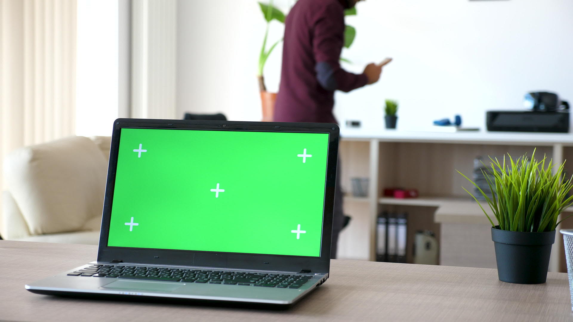 客厅桌子上的膝盖电脑有绿色屏幕和跟踪标记视频的预览图