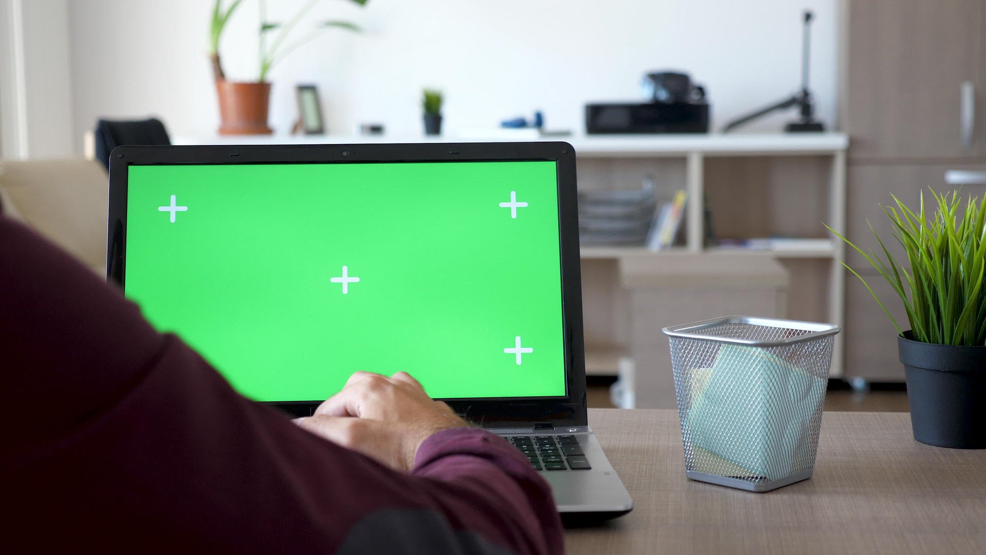 在笔记本电脑上工作的人的背面有一个绿色的屏幕视频的预览图
