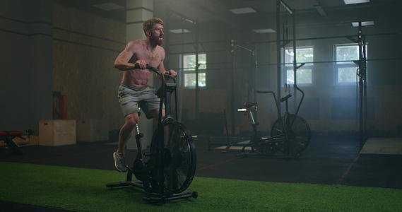男子运动自行车健身房骑自行车训练健身使用空气自行车视频的预览图