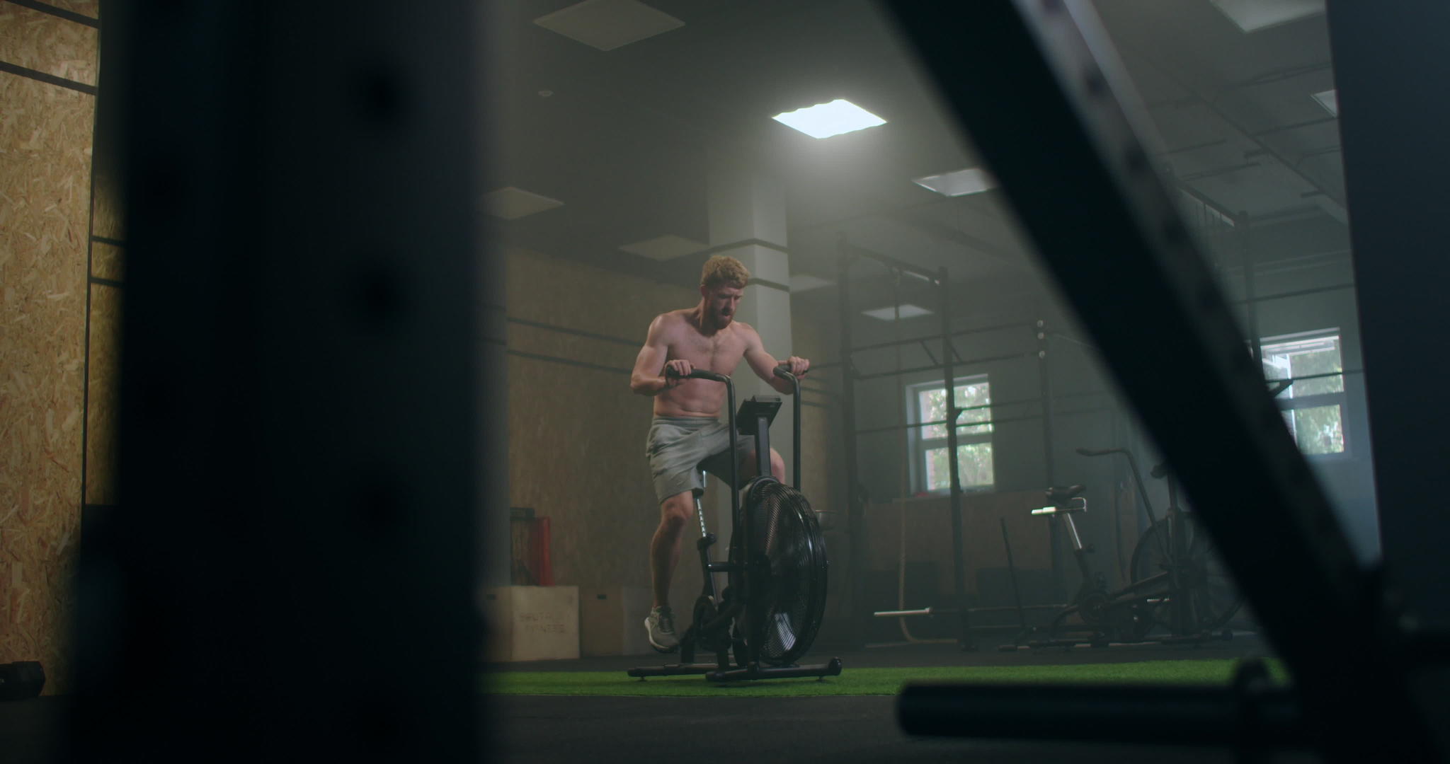 在健身房强壮的男人用机车在健身房做心脏锻炼设备视频的预览图