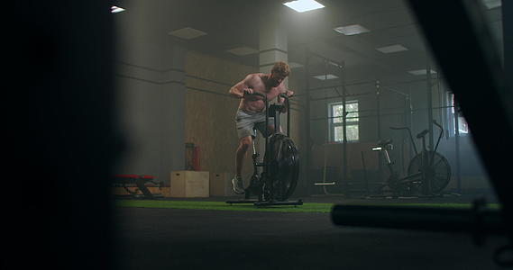 一个硬汉在健身房的固定自行车上克服疲劳视频的预览图