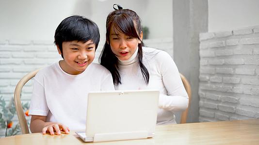 母亲和儿子用笔记本电脑聊天视频的预览图