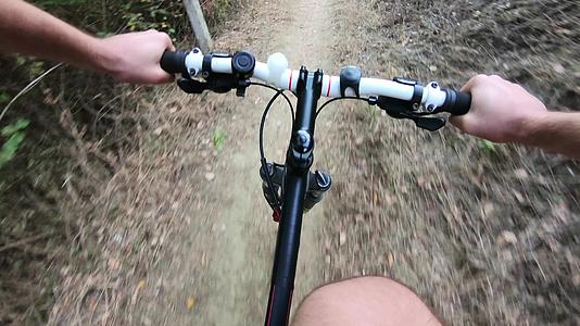 秋天的颜色是第一个视角最初的观点是在森林里肮脏的路上骑自行车视频的预览图