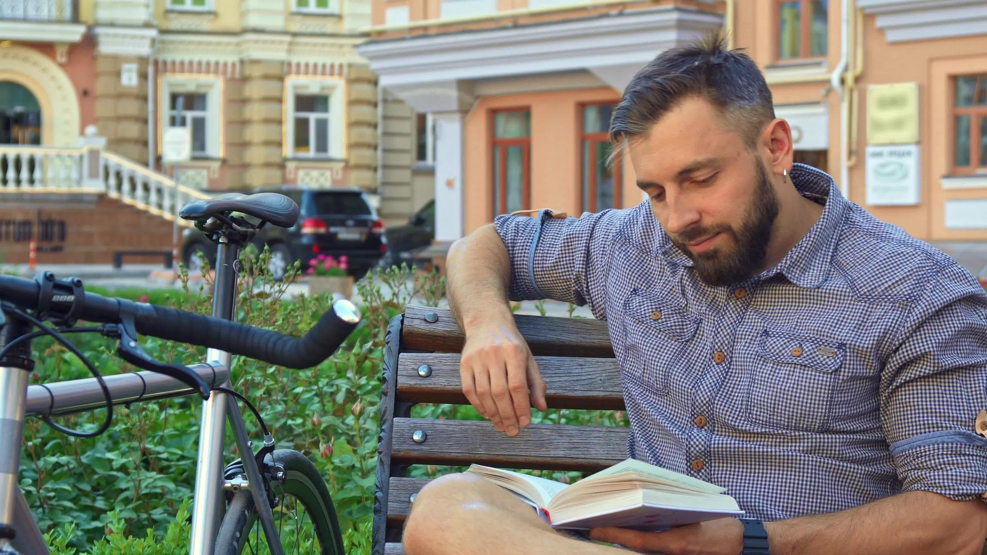 骑自行车的人在板凳上翻过书页视频的预览图