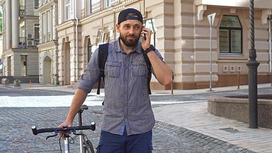 骑自行车的人在街上使用手机视频的预览图