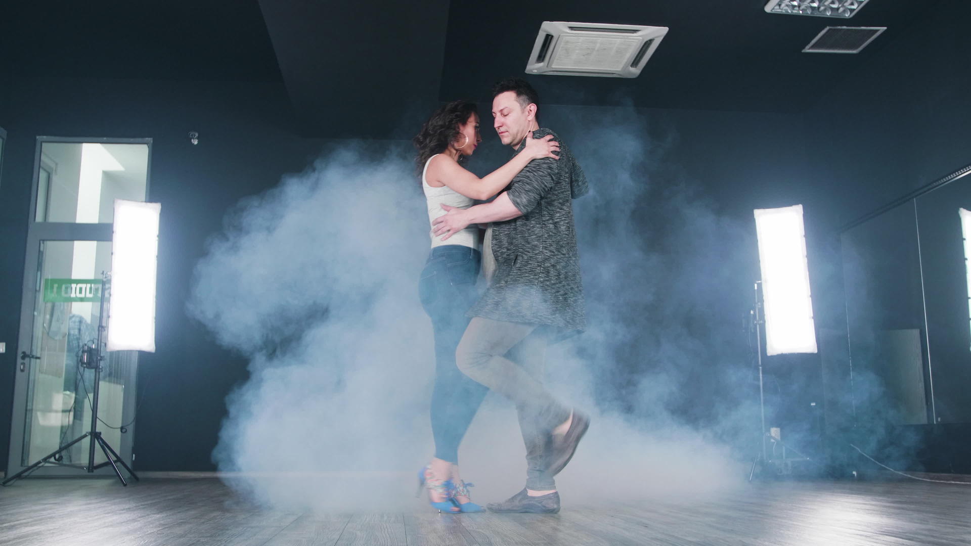 年轻夫妇在明亮的灯光板上用烟跳吉宗巴舞视频的预览图