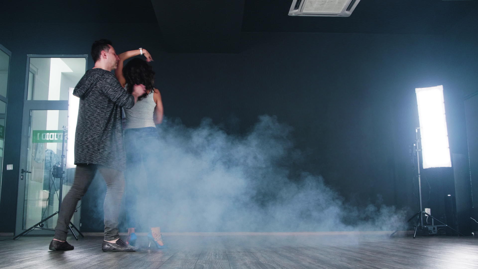 一对美丽的情侣在舞蹈室的黑色背景前跳舞视频的预览图