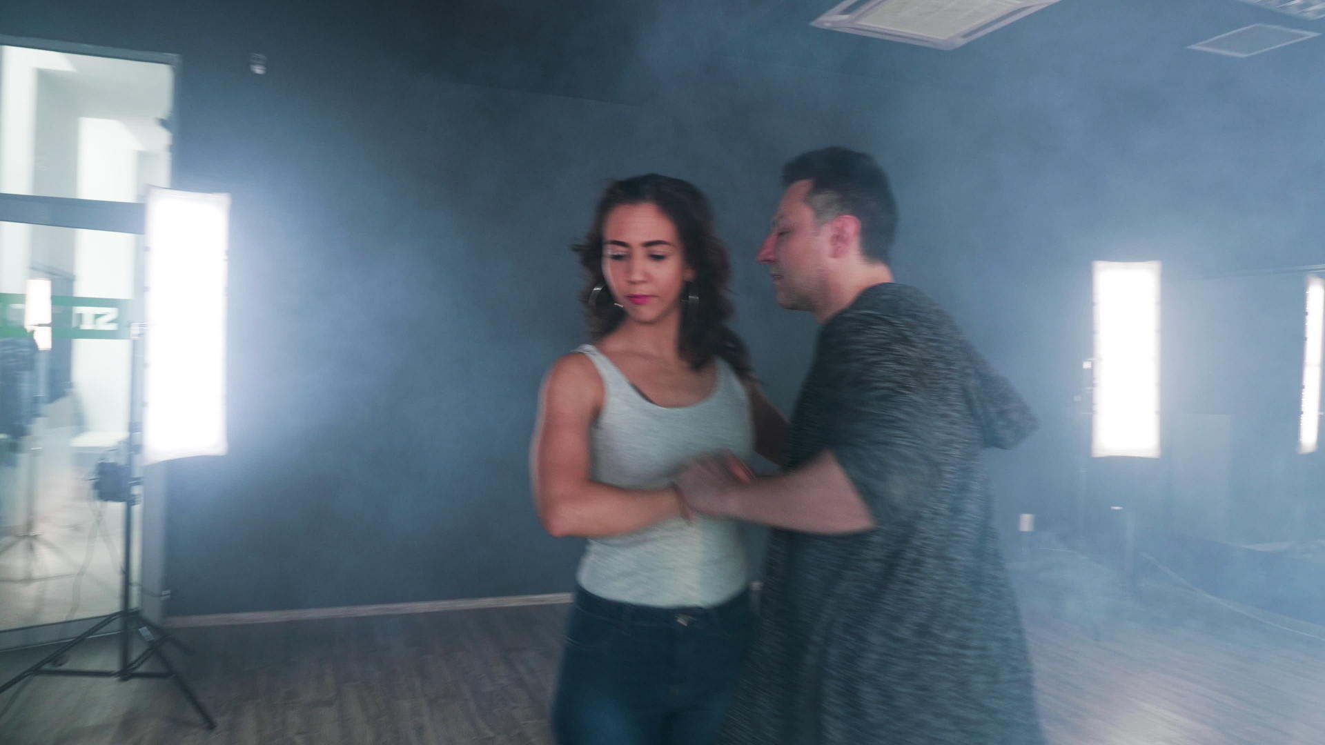 一对夫妇在一个烟雾的明亮工作室里跳舞视频的预览图