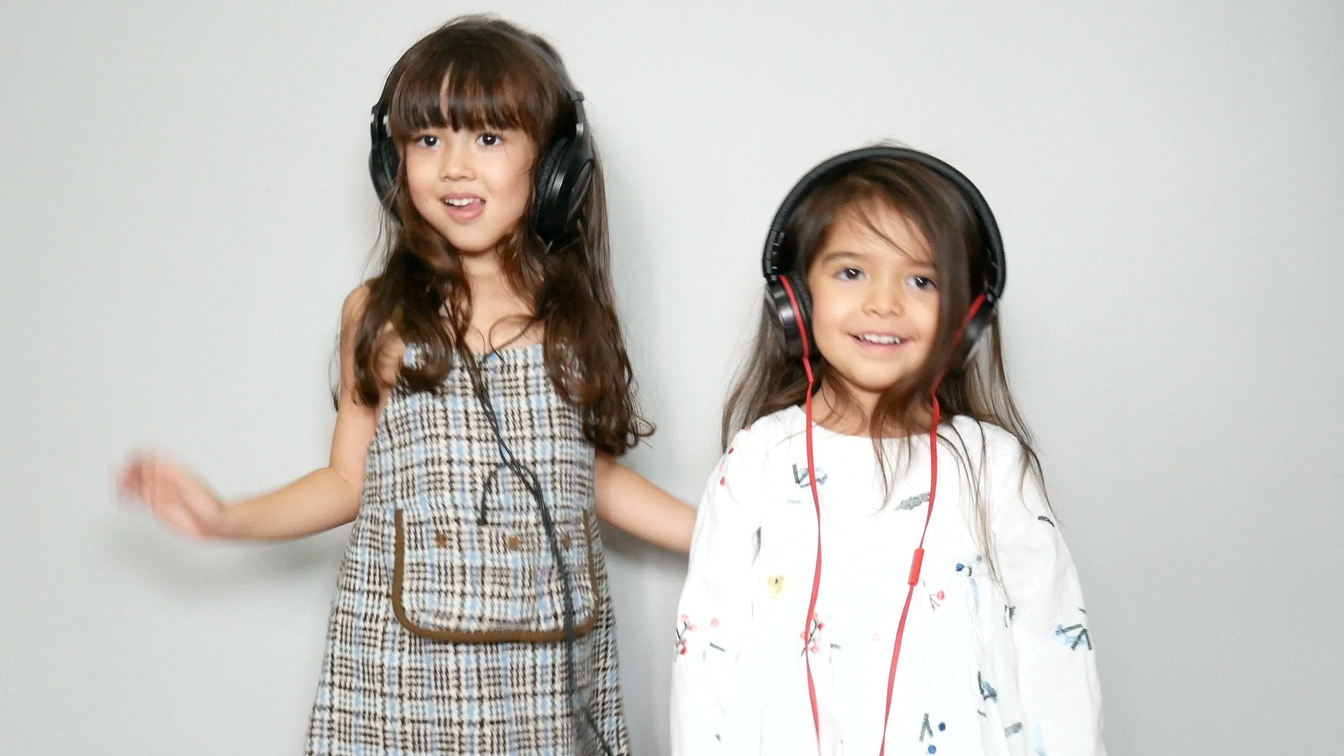两个可爱的姐妹混血女孩享受音乐和耳机舞蹈休闲活动视频的预览图