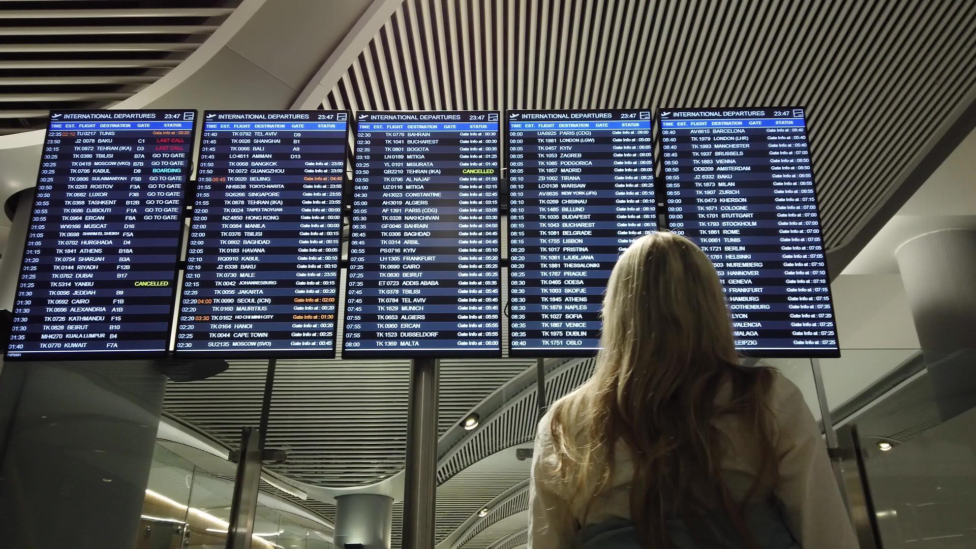 在国际机场查看航班信息板的女性视频的预览图