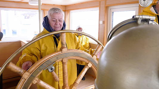 老妇人把方向盘转向帆船的船长桥成熟的女人掌舵视频的预览图