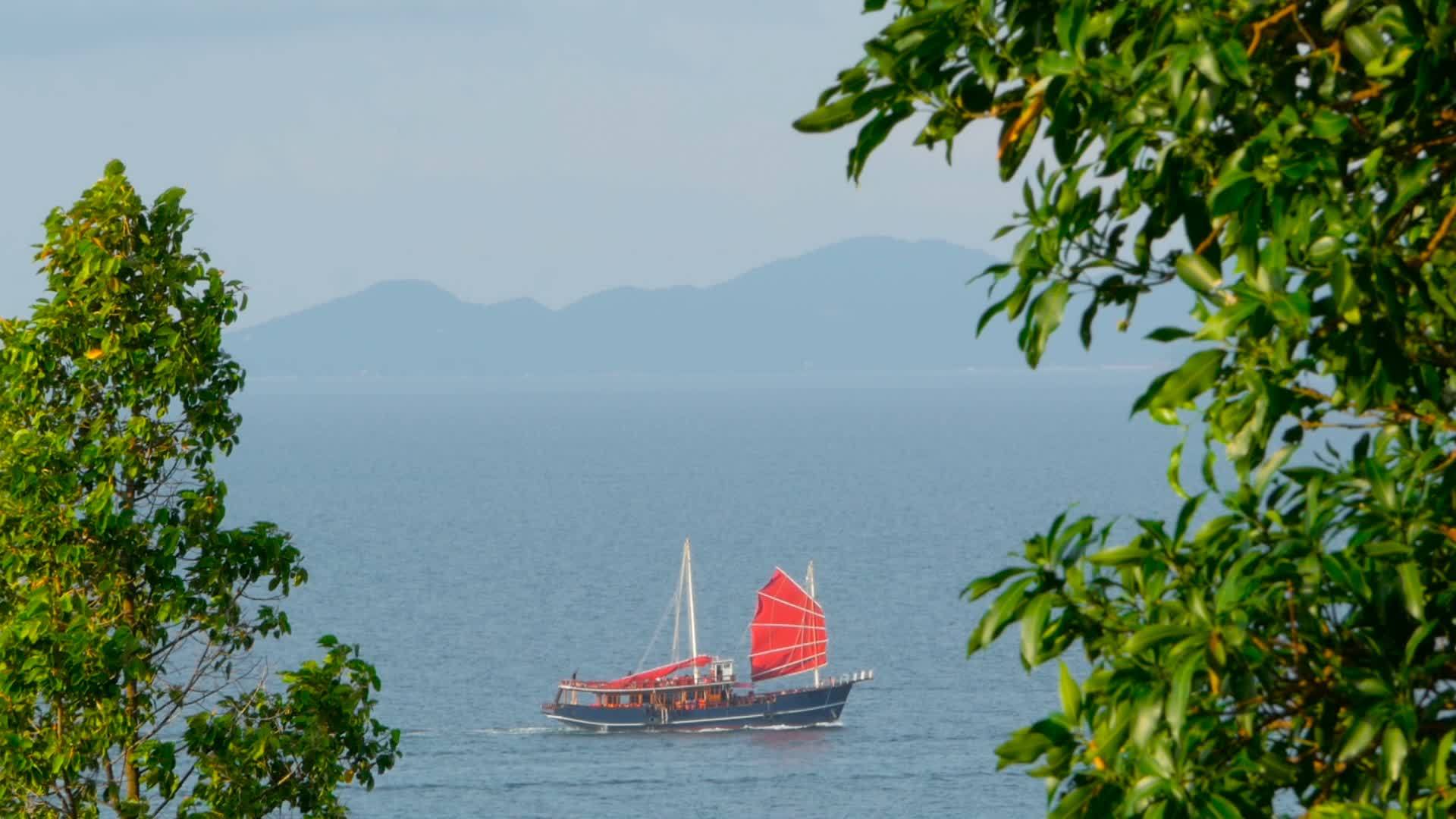 传统的船在日落时有红色的帆在海上漂浮视频的预览图