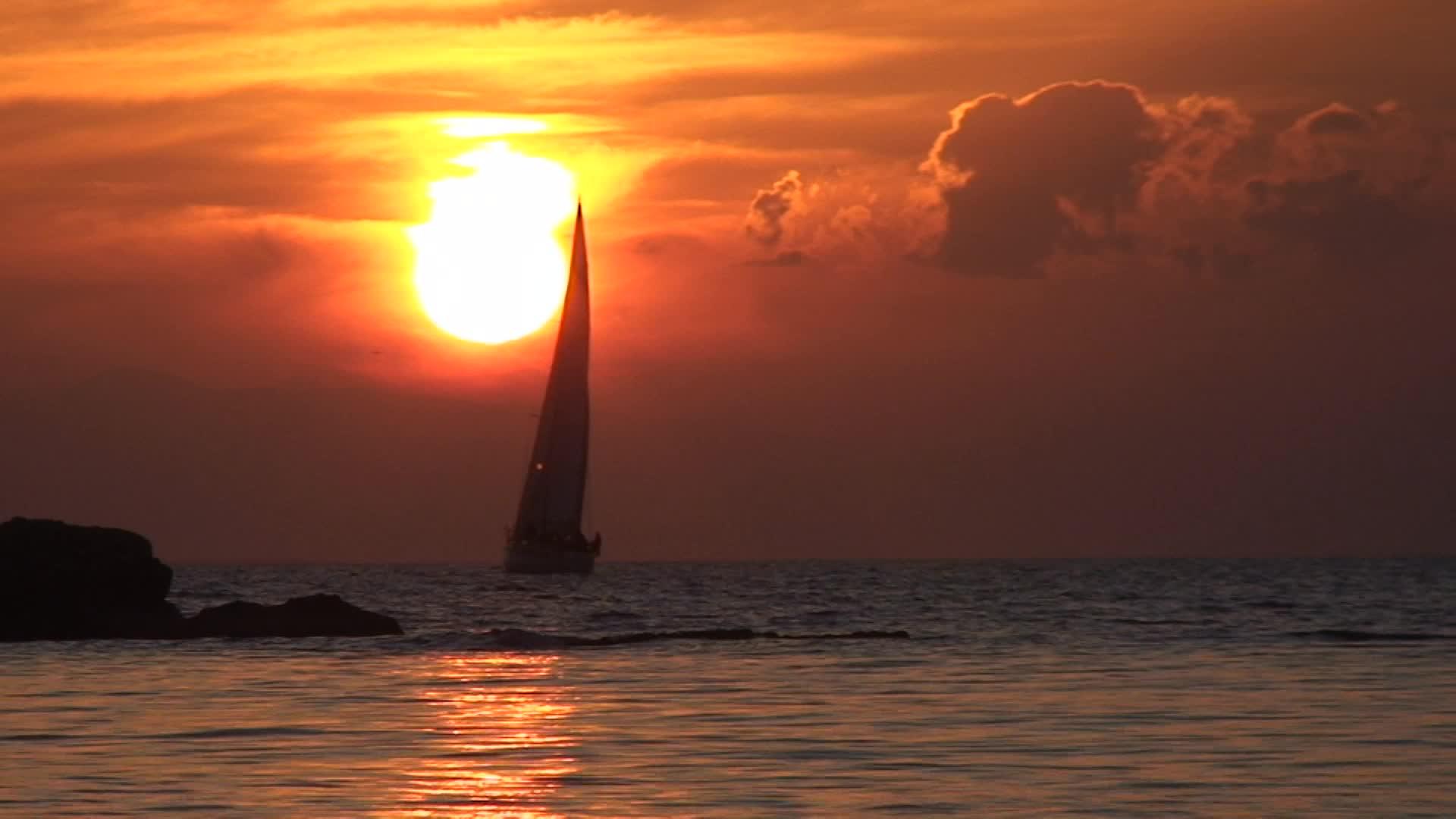 日落时帆船在太阳前经过视频的预览图