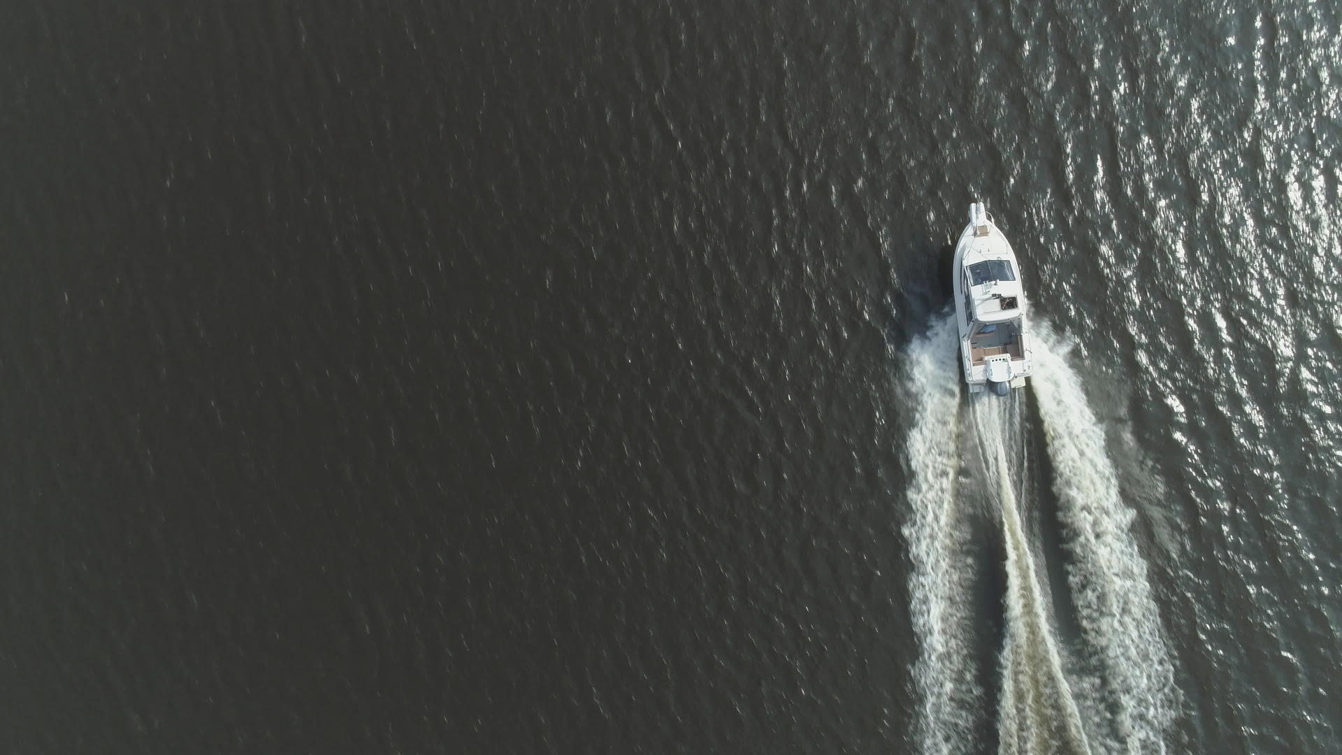 在阳光明媚的日子里豪华的高速摩托艇在空中垂直俯视视频的预览图