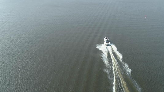 在阳光明媚的日子豪华快艇驶入海湾鸟瞰图显示射击无人机视频的预览图
