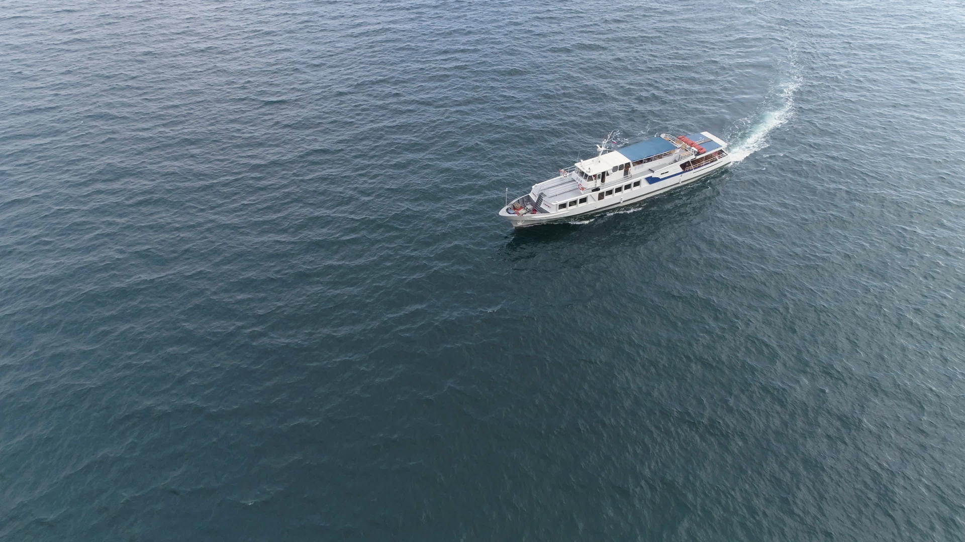 小型白色游轮正在海上航行无人驾驶飞机正在调查这艘船像机视频的预览图