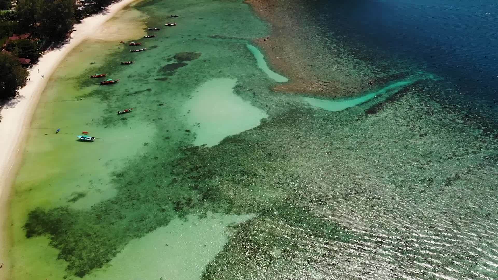 漂浮在平静的蓝色水面上的热带异国天堂岛白沙海岸附近视频的预览图