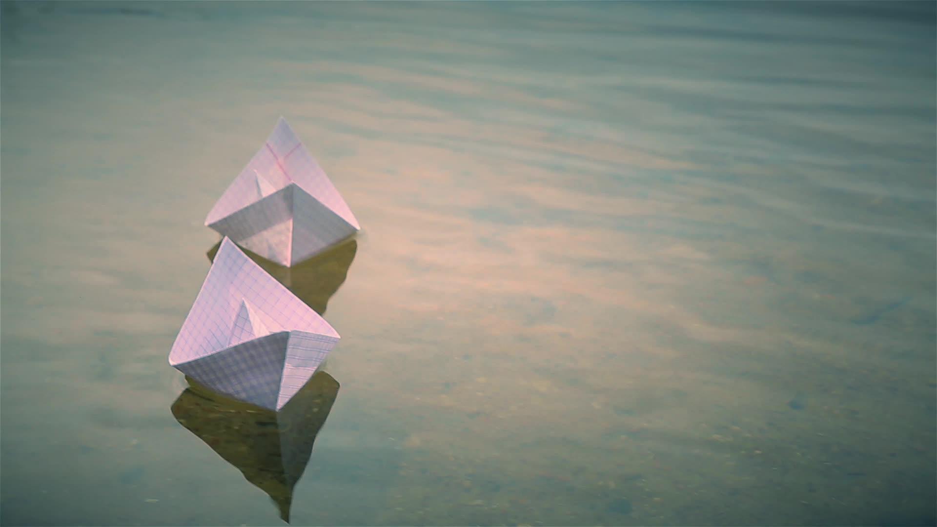 两艘小纸船漂浮在湖面上视频的预览图