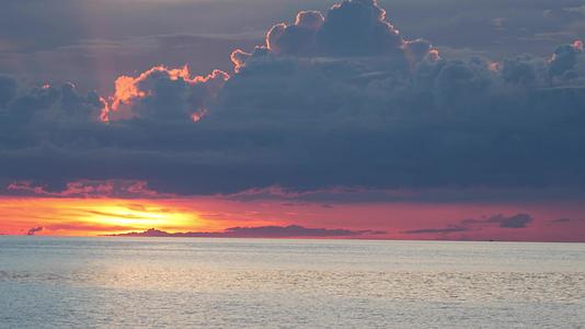 日落时在海上划船日落时在多云的傍晚漂浮在平静的海面上视频的预览图