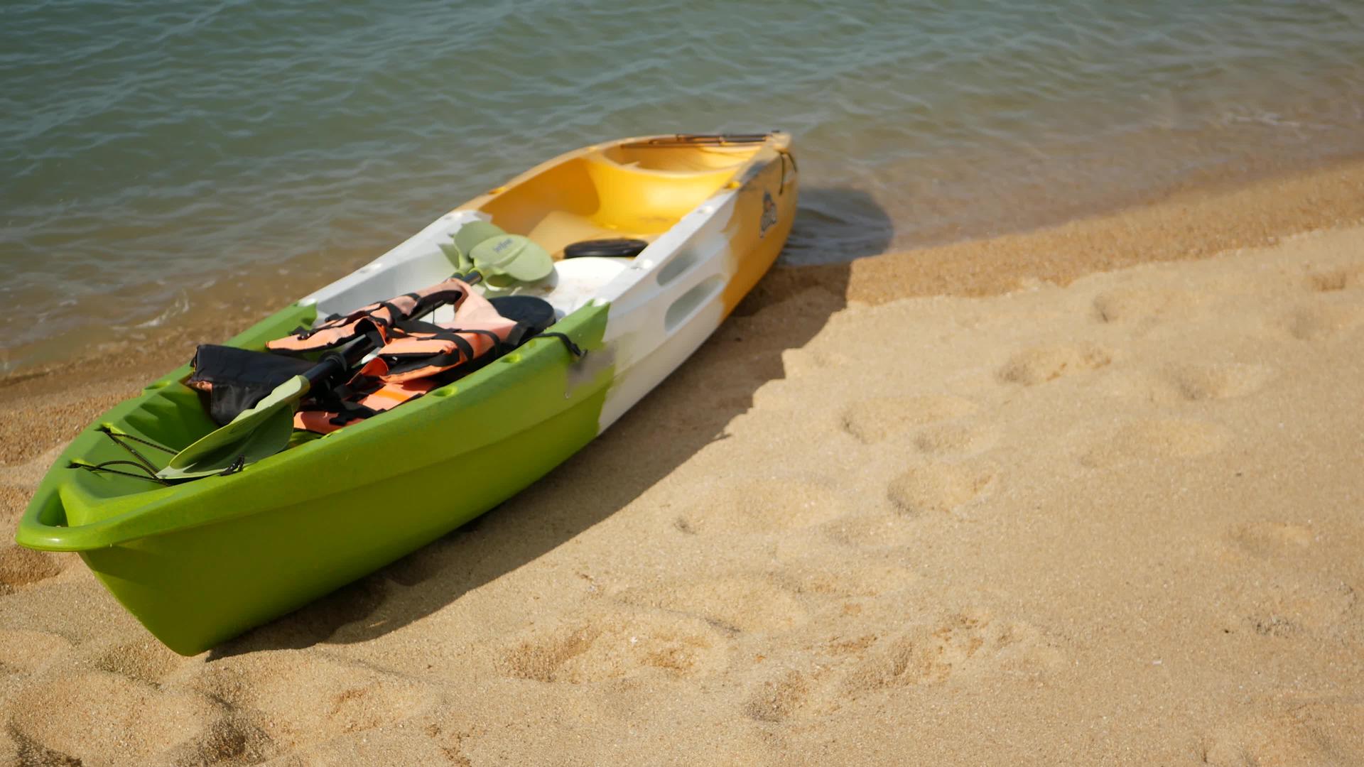 用桨划在沙滩上的皮划艇被蓝色的海浪冲走了视频的预览图