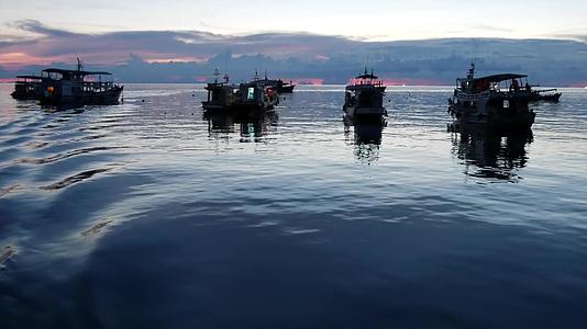 日落时漂浮在港口海面上的小船泰国海洋表面视频的预览图