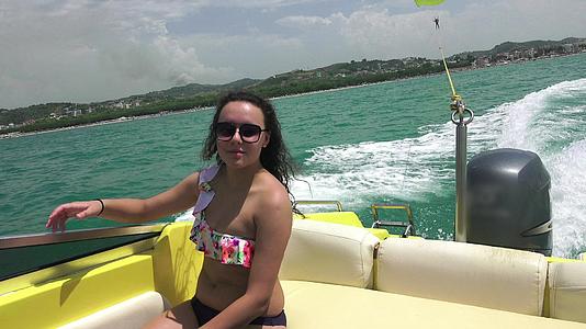 在阳光明媚的夏天穿着比基尼的漂亮女孩在游艇上微笑视频的预览图