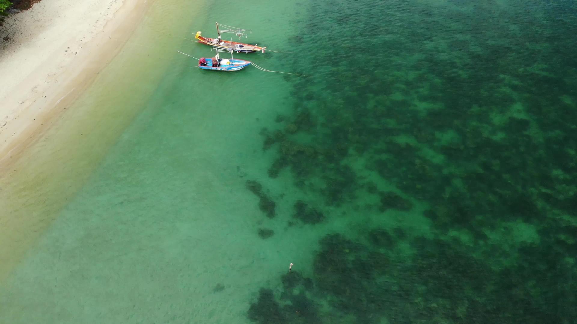 渔船漂浮在雄伟的珊瑚礁附近的蓝色的蓝色视频的预览图