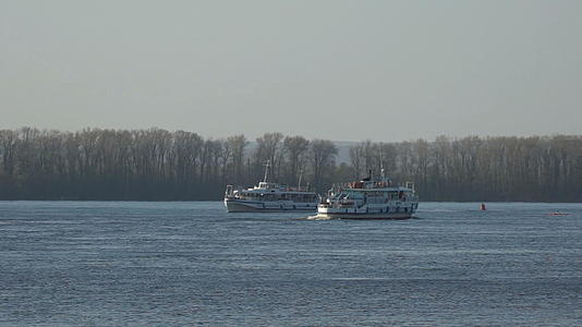 两艘船在河岸上航行视频的预览图