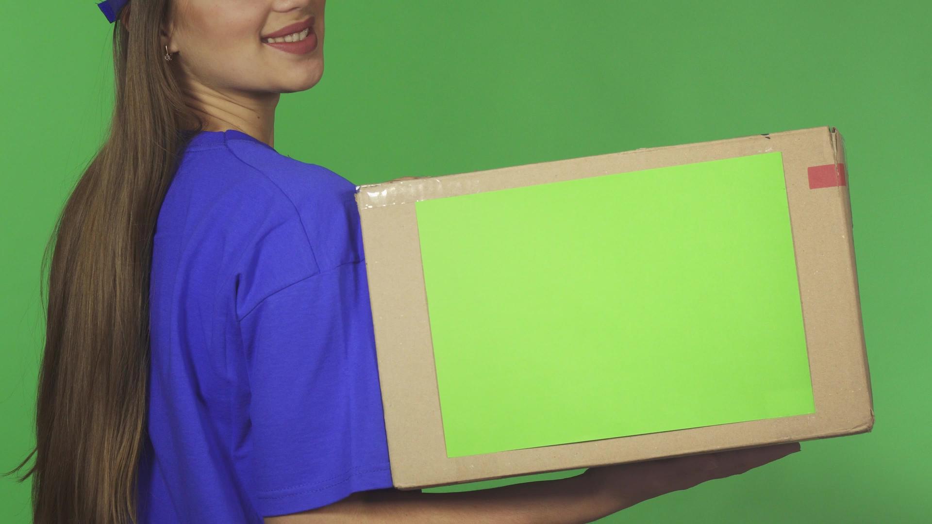 一名微笑的女送货员拿着一个纸箱被拍到后视镜视频的预览图