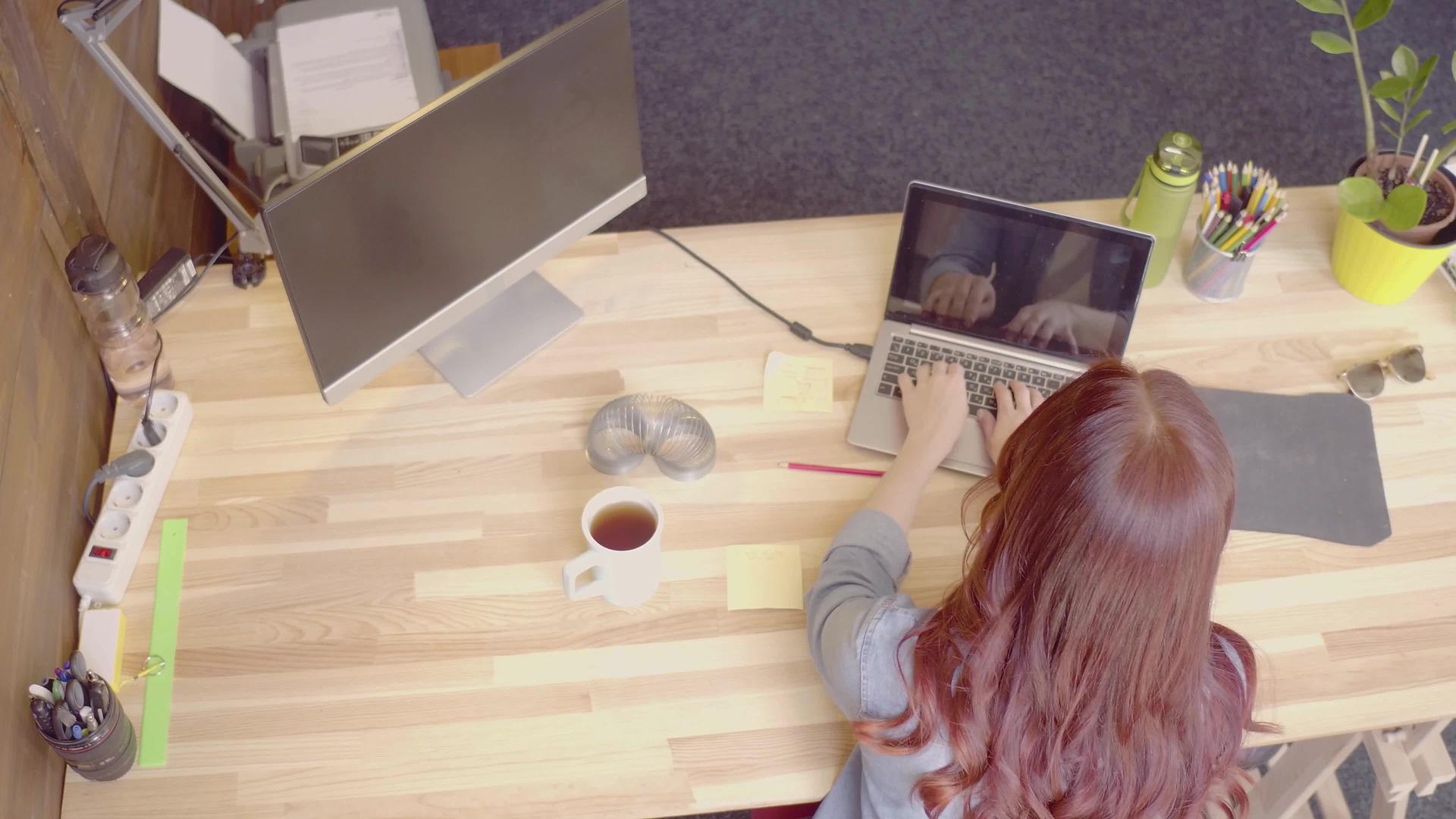 红发自由职业女性工作大腿顶部电话交谈视频的预览图